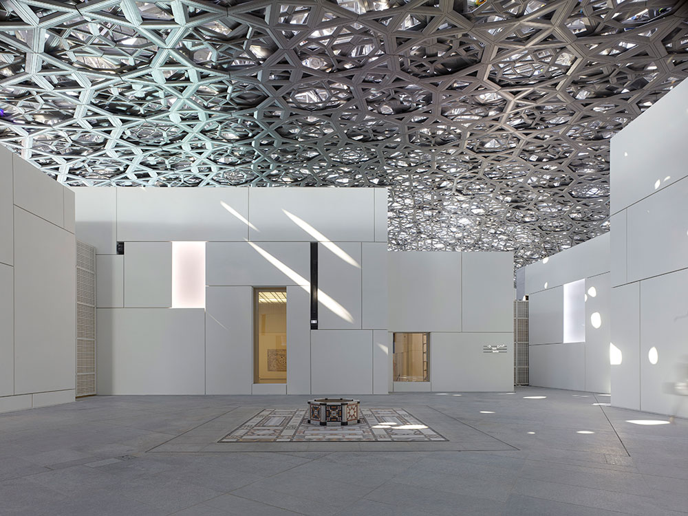 The complex structure of the domed roof of the Louvre, Abu Dhabi creating the “Rain of Light” in the exhibition space of the Ottoman mosaic pavement. - © Photography by Roland Halbe . Architecture by Jean Nouvel. Engineering by BuroHappold. Steel construction Waagner Biro.