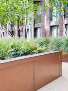 Integrated planters in Bronze sandblasted PVD coloured stainless steel. - Embassy Gardens, Nine Elms, Wandsworth, London, UK. - Landscape Architect: Camlins; Hyland Edgar Driver - Bespoke design and fabrication: John Desmond Ltd working with In-Ex Landscapes.